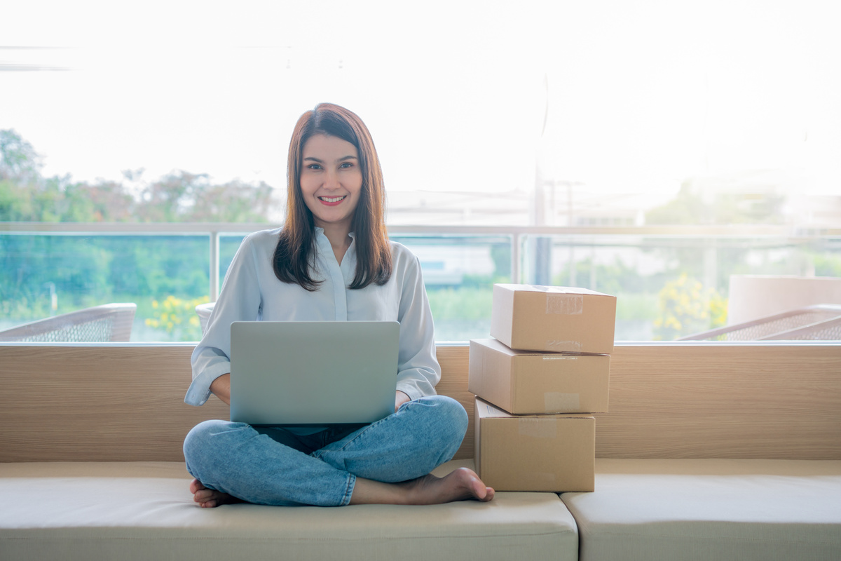 Happy Young Asian Woman Entrepreneur, Smile for Sales Success after Checking Order from Online Shopping Store in a Laptop at Home Office, Concept of Merchant Business Online and ECommerce